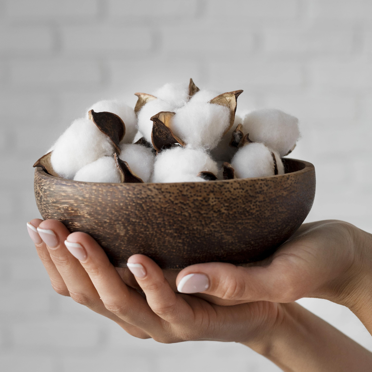 menstruationsprodukter, økologisk bomuld, i skål, holdt i kvindes hænder 